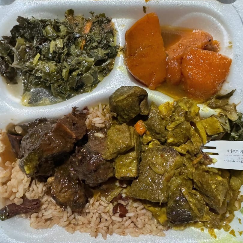 A Jamaican meal with stewed greens, candied yams, brown rice, curry goat, and stewed beef.